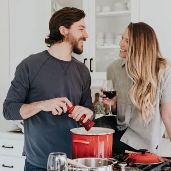 Couple smiling while cooking dinner together