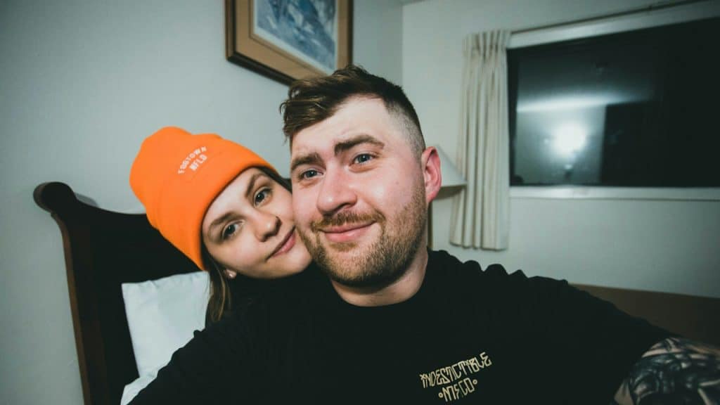 A man and a woman smiling and taking a selfie.