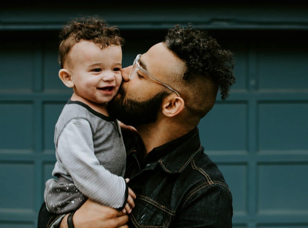 The man is kissing his son.