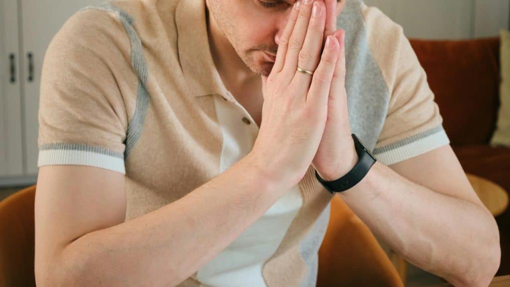 A person with hands pressed to their face, appearing stressed.