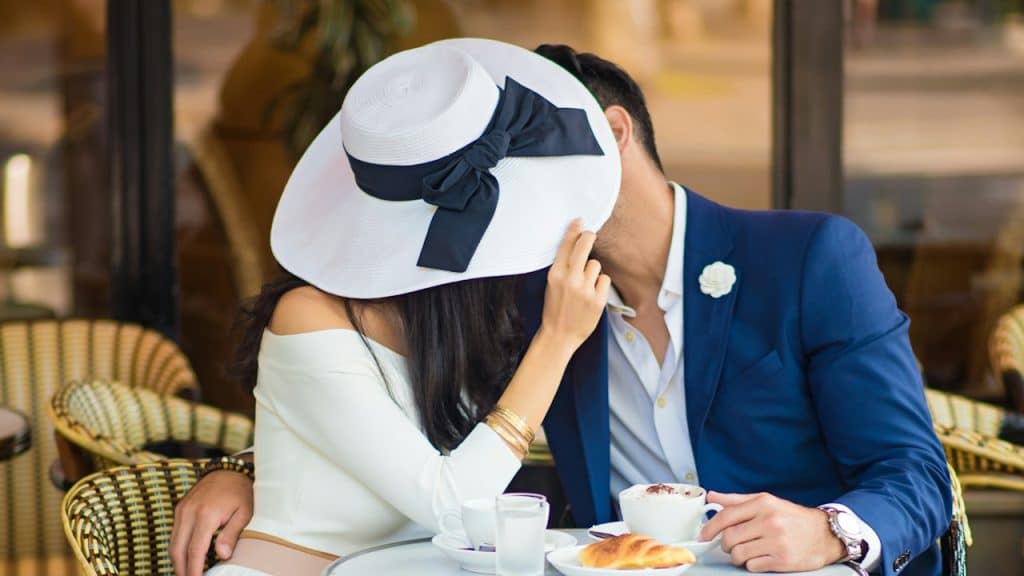 A man and woman kissing each other in a restaurant.