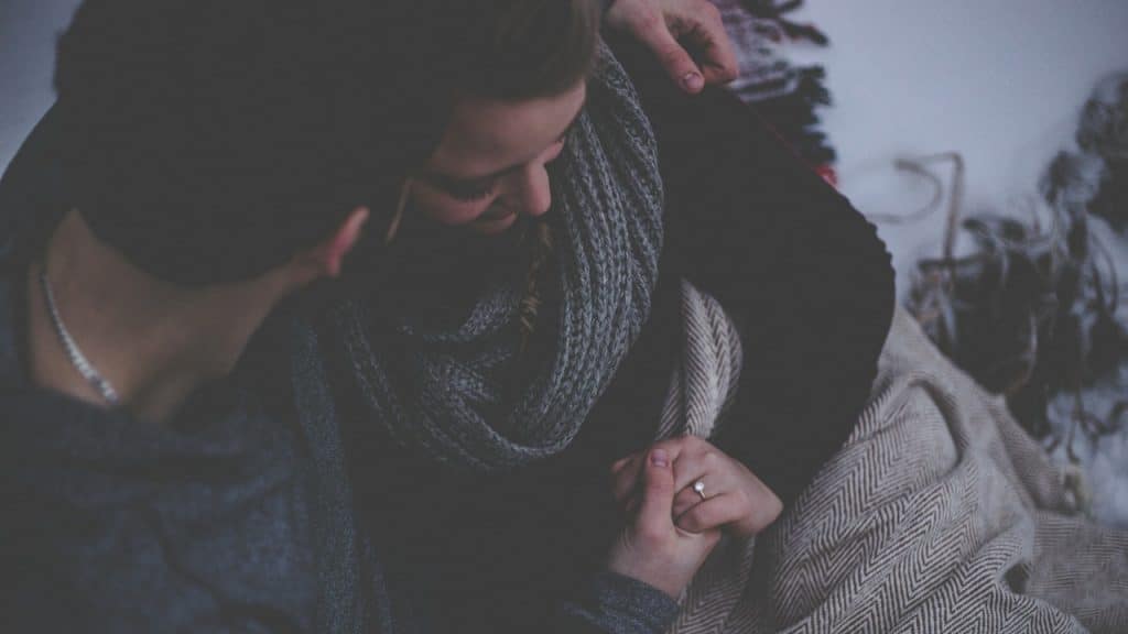 Couple with a grey blanket.