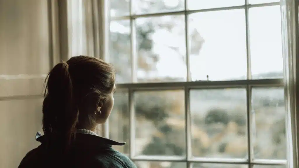 A woman looks out a window.