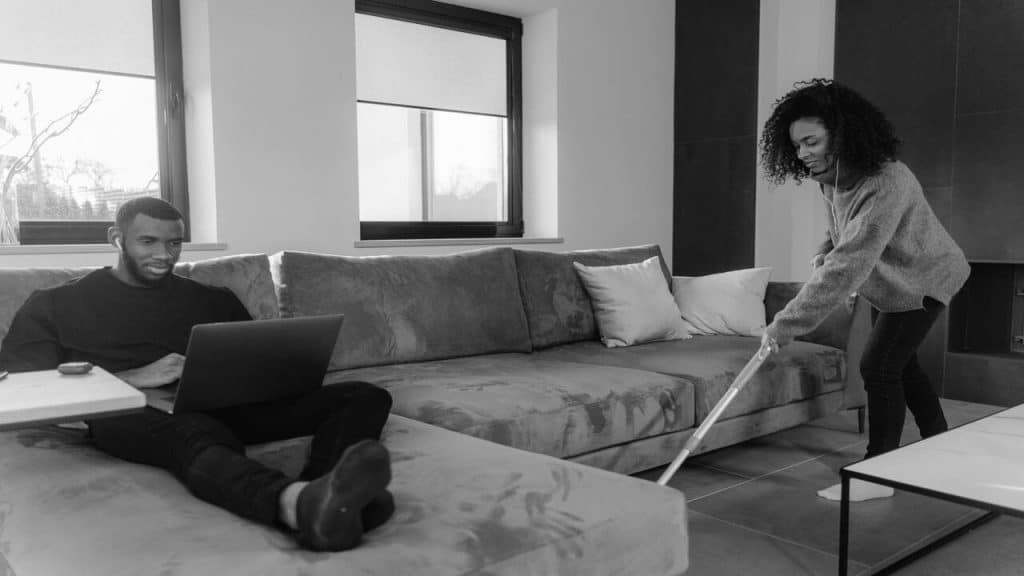 A woman cleans while her husband works