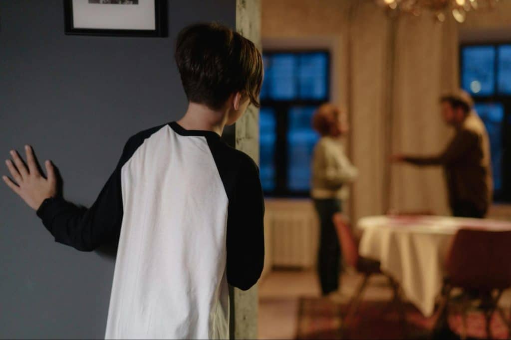 A man and woman fighting in front of the kid