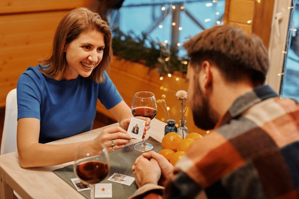 Couple Playing Cards on Table with Wine