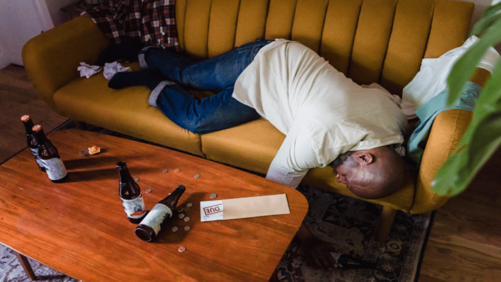 A man sleeping on the couch due to drunkenness