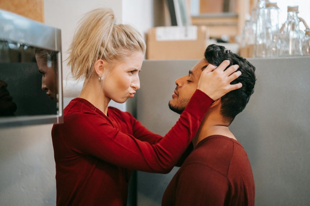The woman lovingly touches the man’s hair.