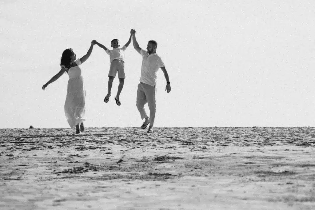 A couple enjoying with their kid at the beach.