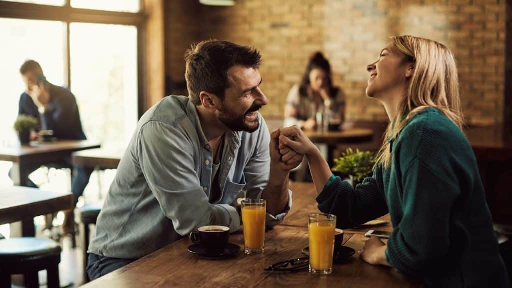 A couple talking and smiling in a cafe. 
