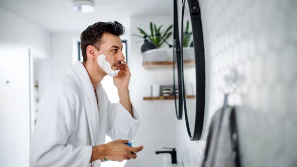 Man shaving in the bathroom mirror
