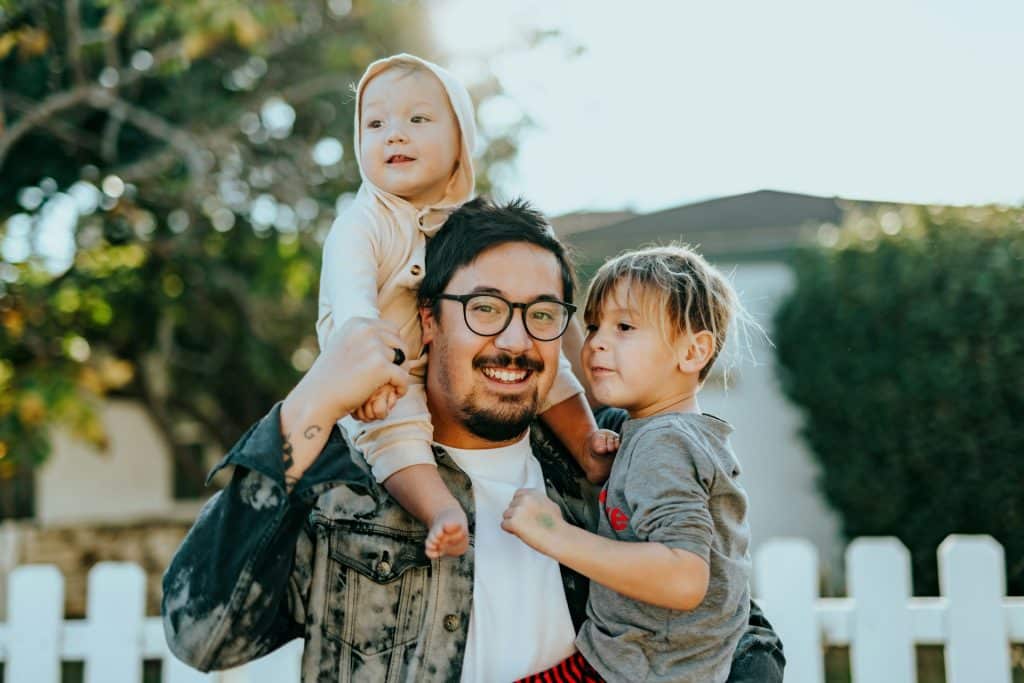 The man is carrying his children.