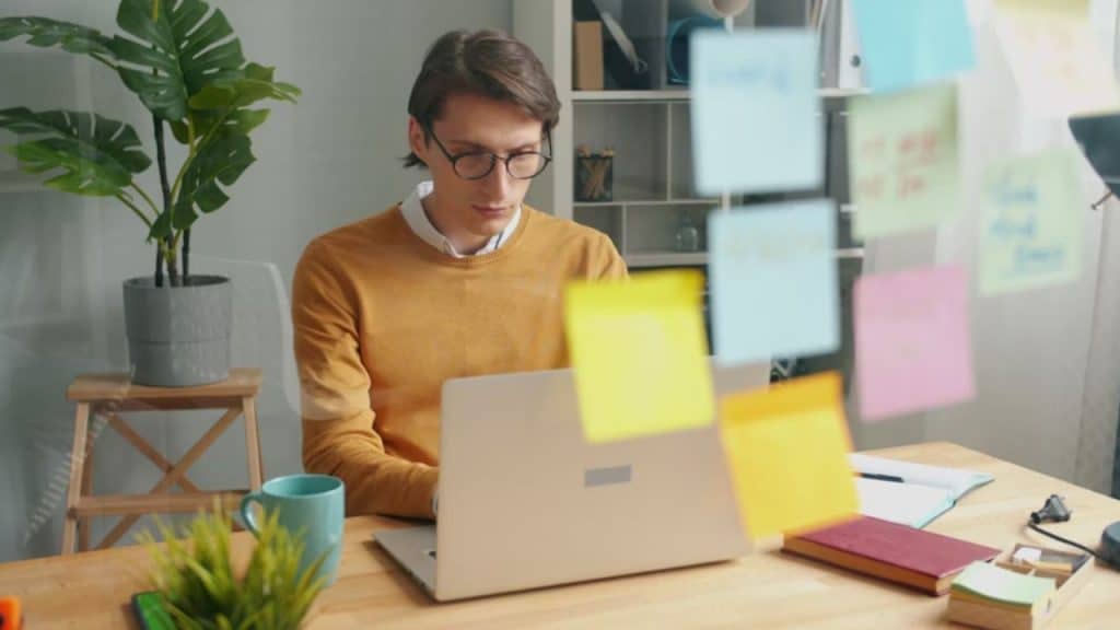 A man quickly closing his laptop as someone walks in