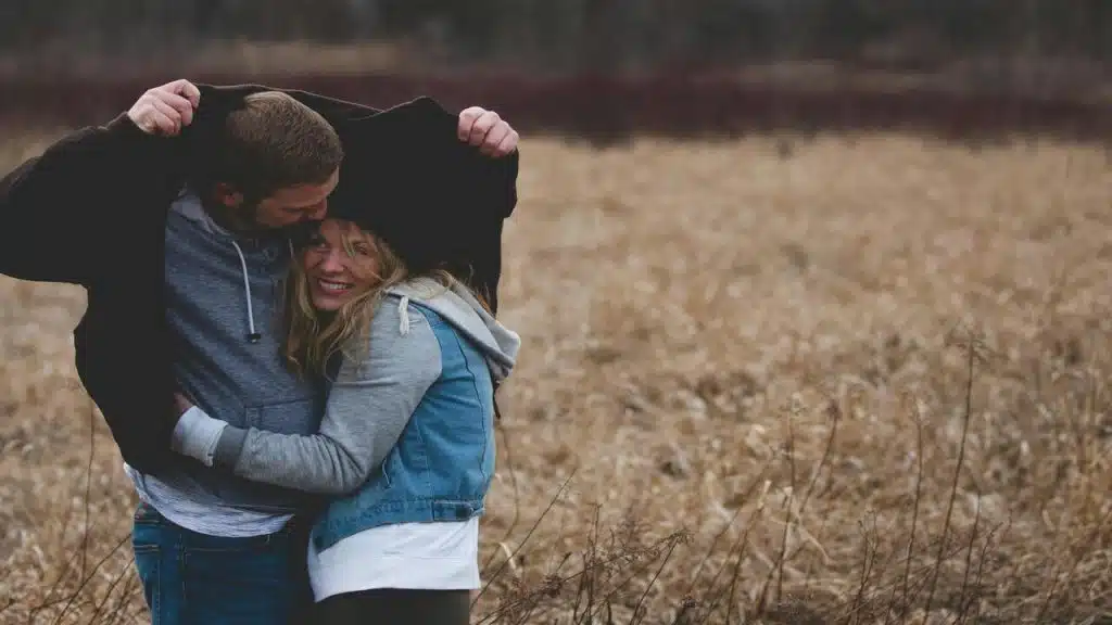 A man sharing a jacket on a field 