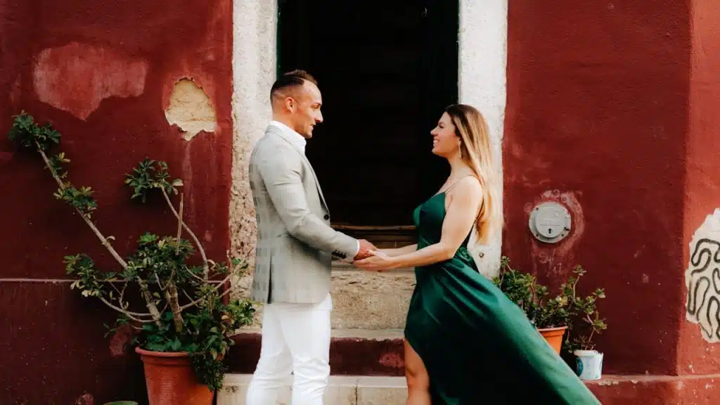 A man and a woman standing in front of a red building.