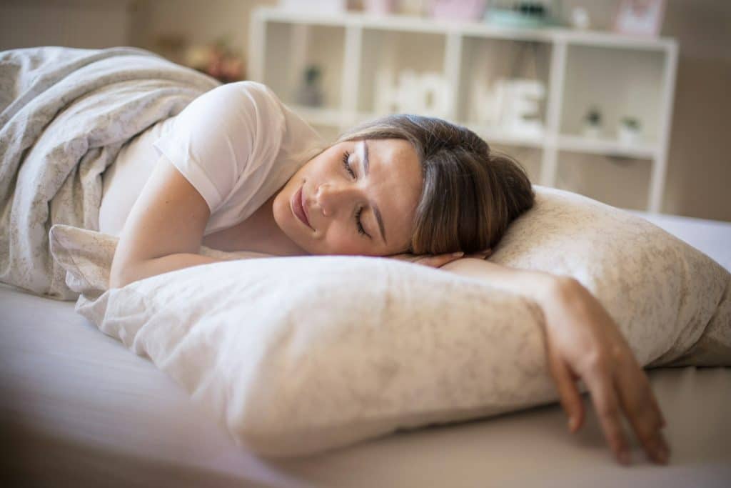 The woman is sleeping peacefully in her bed.