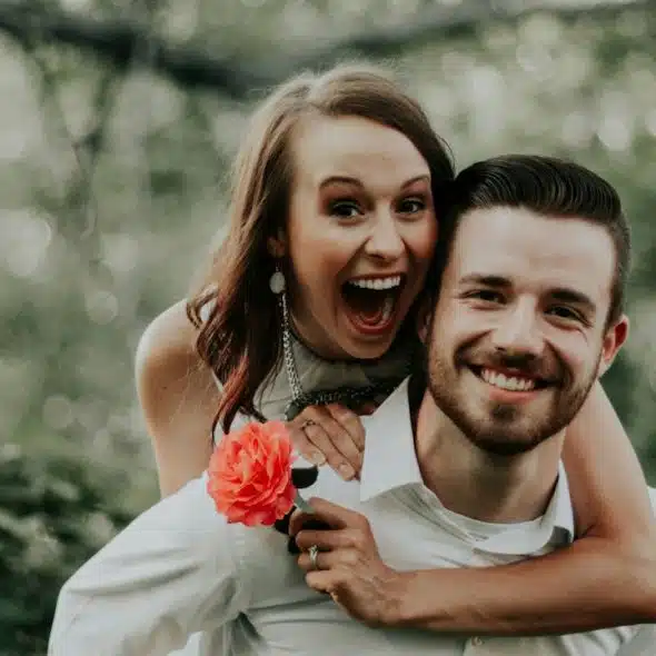 A woman riding on the back of a man.