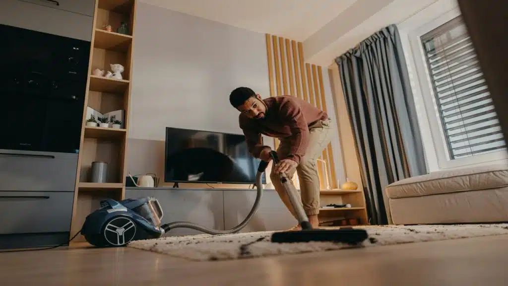 A man cleaning the living room