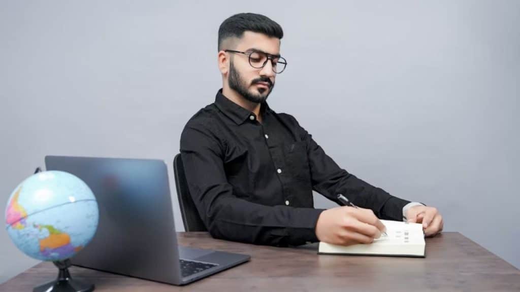 Man sitting at a desk reviewing plans with determination
