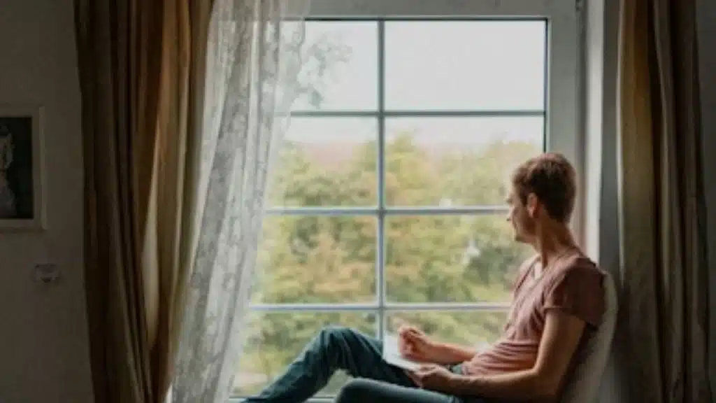 Man journaling or reading near a window