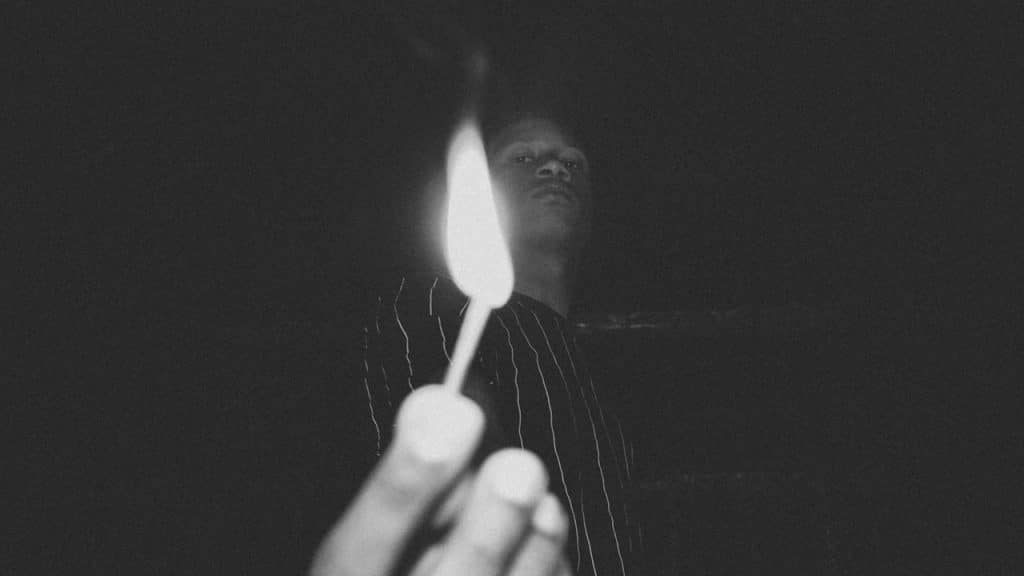 Person holding burning match stick.