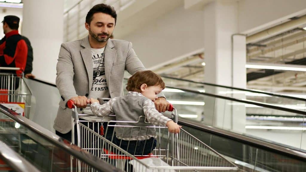 A dad with his baby while doing the groceries