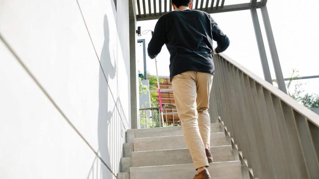 A man walking up a concrete staircase outdoors.