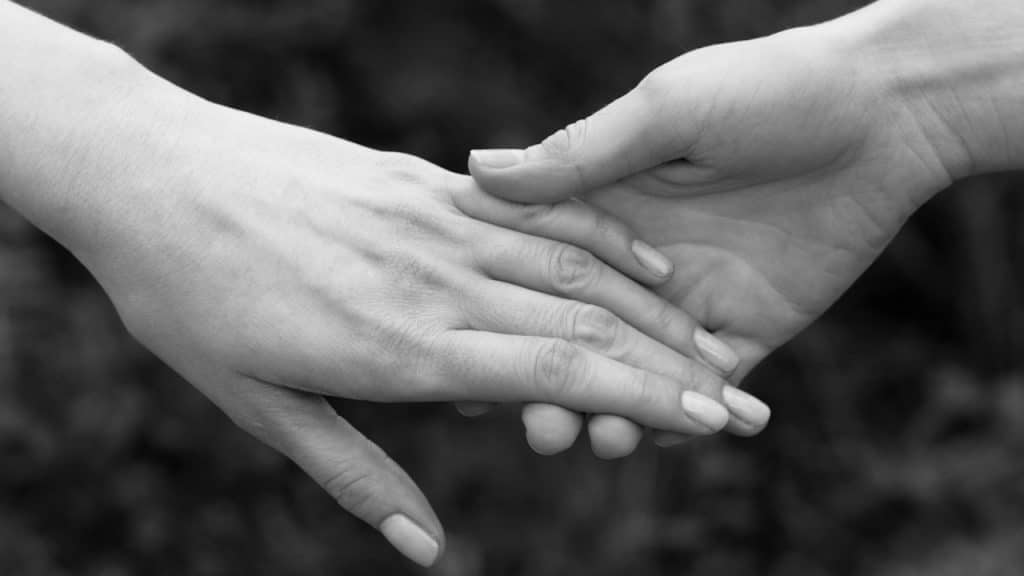 Closeup of a couple holding hands.