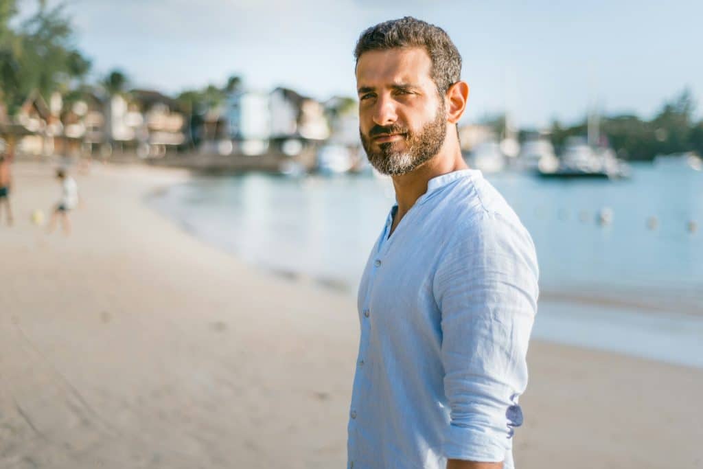 The man standing on the beach exudes confidence.