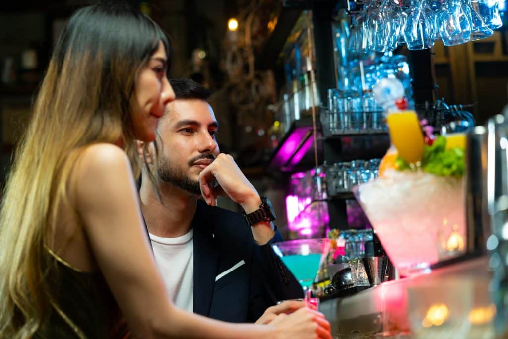 The man is buying the woman a drink.