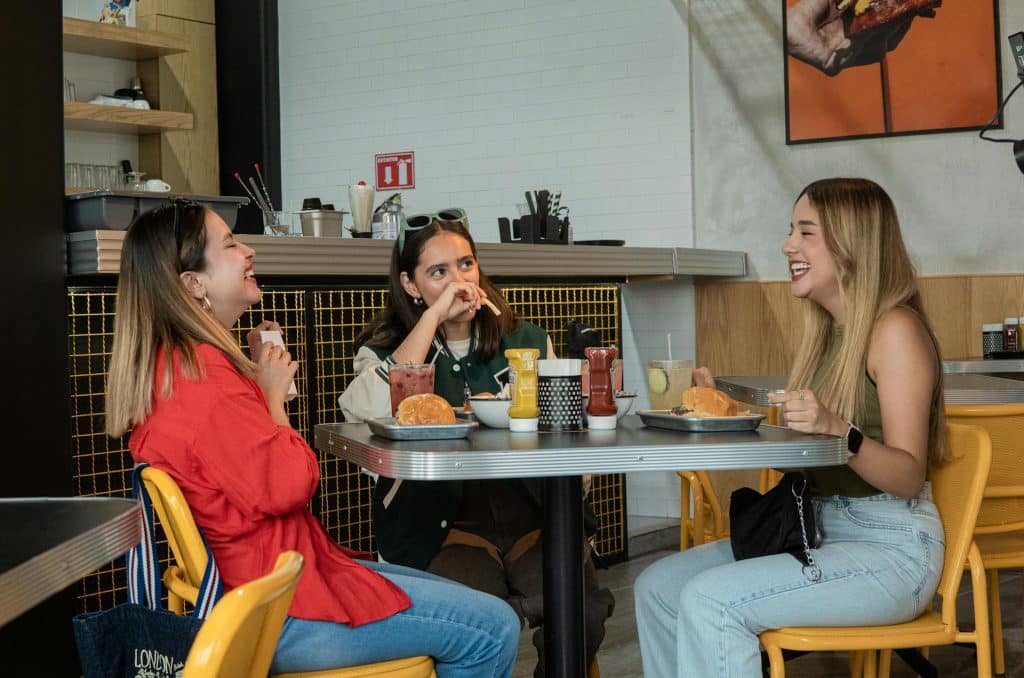 The friends are eating burgers in a restaurant.