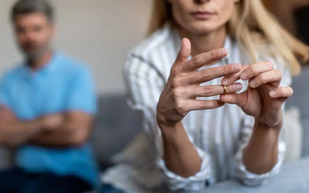 The woman is taking off her wedding ring.