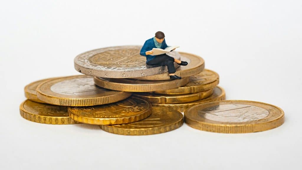 A photo of a figurine man sitting on coins