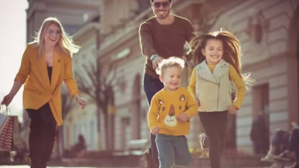 Father playing with children while partner smiles in the background