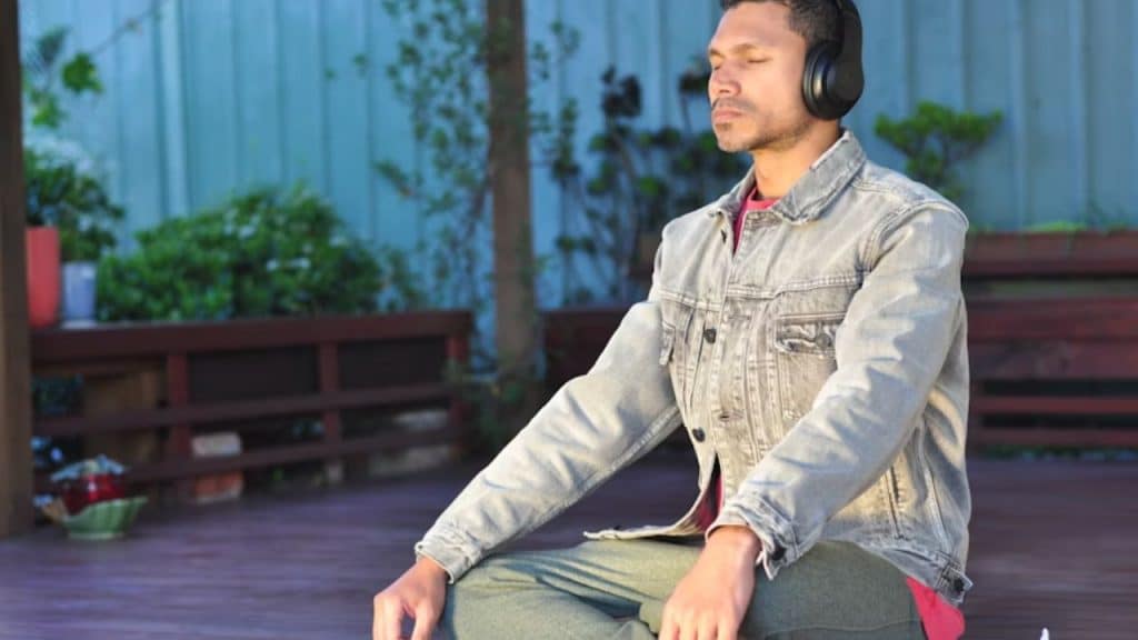 Man practicing deep breathing with eyes closed at home