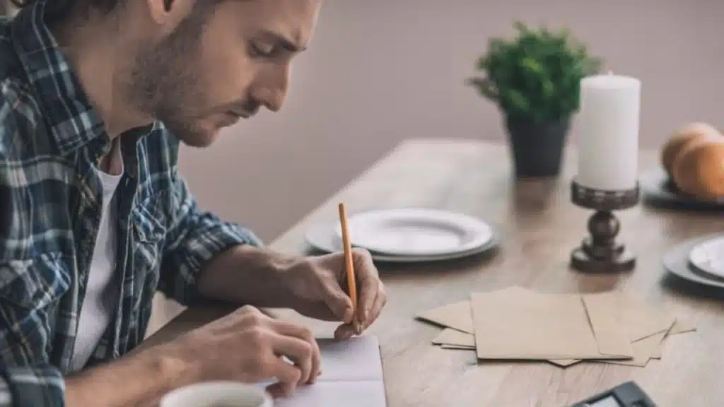 Man sitting with a journal or notes, reflecting quietly