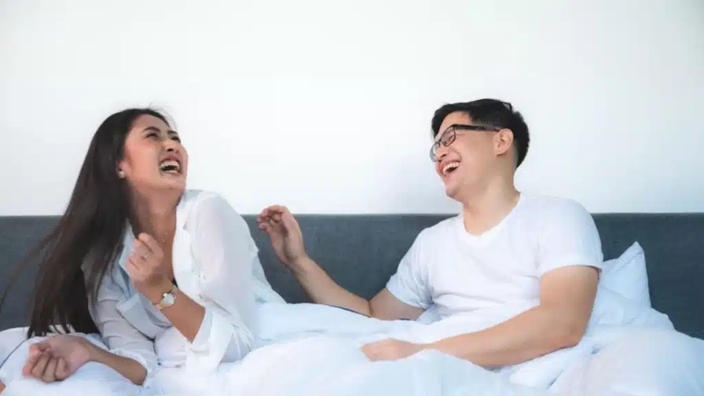 Couple on the bed, laughing out loud