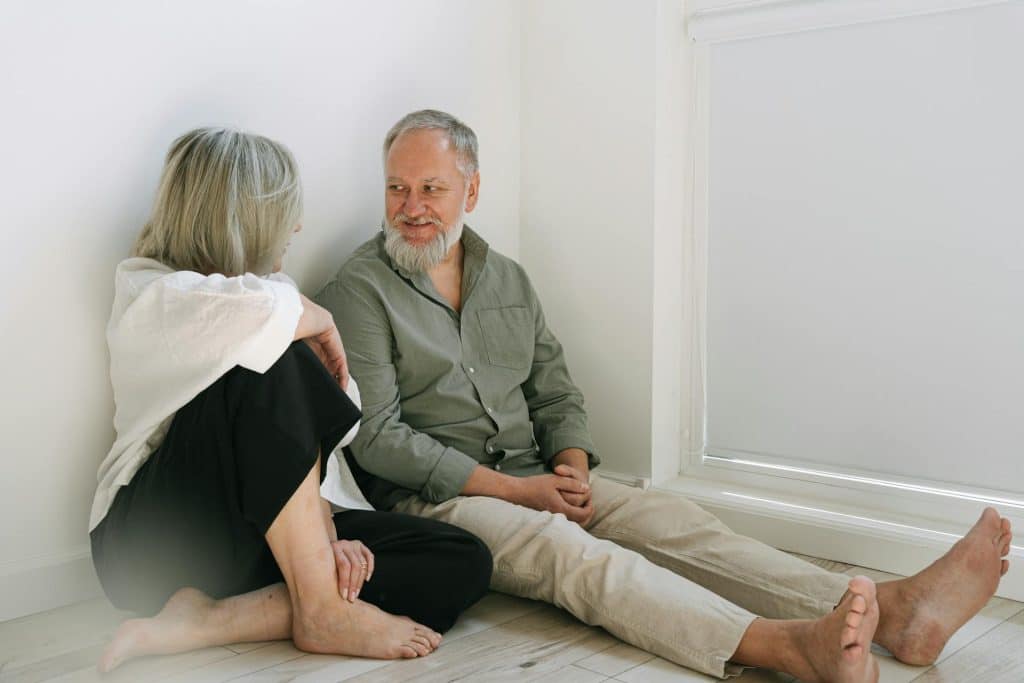 The man and woman are having a conversation sitting on the floor.