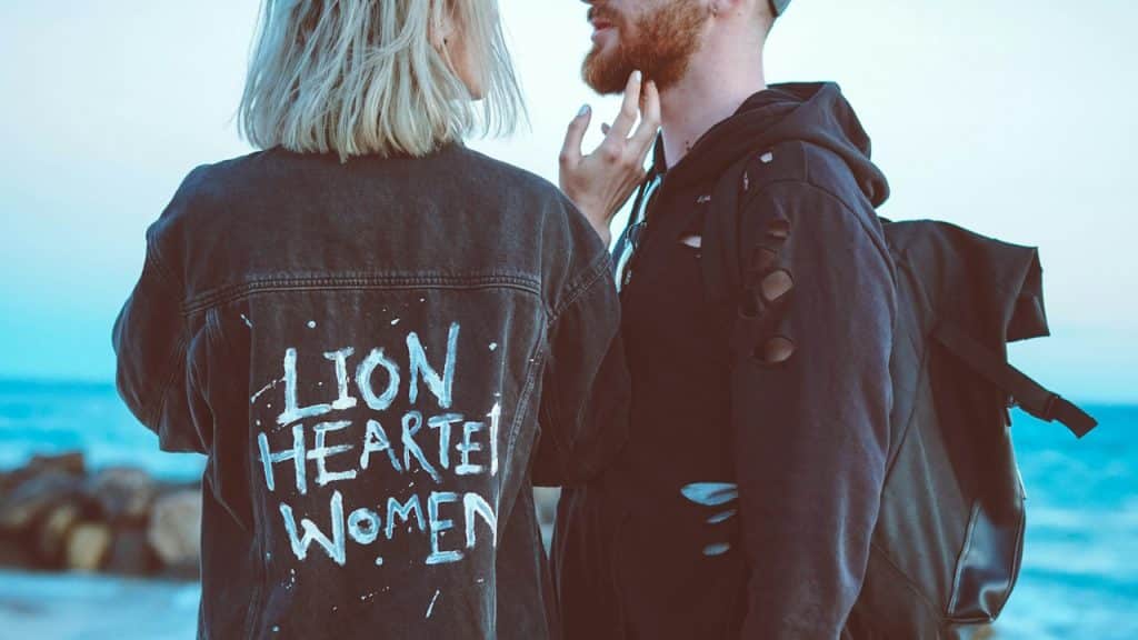 A man and a woman standing beside the sea.