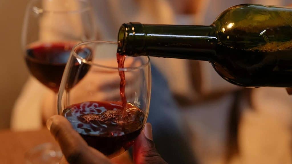 A close-up of red wine being poured into a glass.