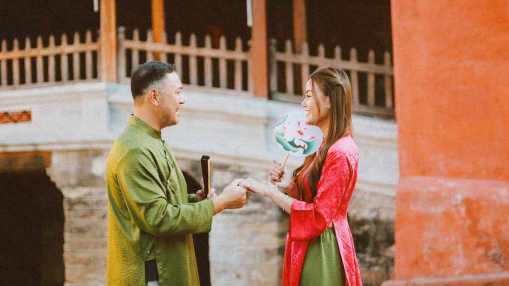A couple smiles while holding their hands.
