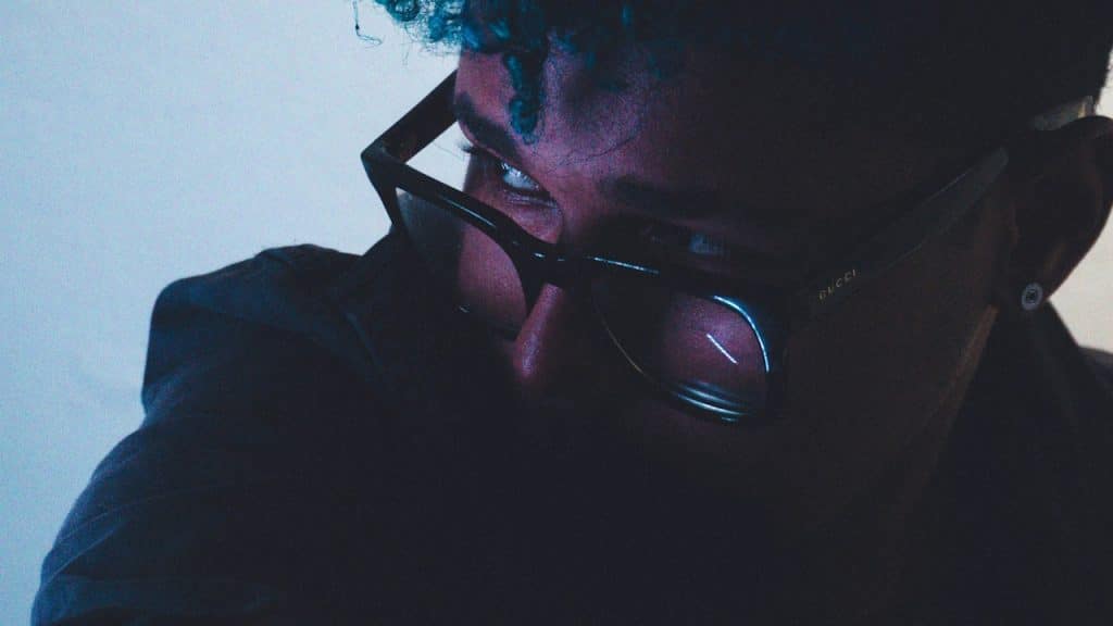 A man with glasses looking to a side.