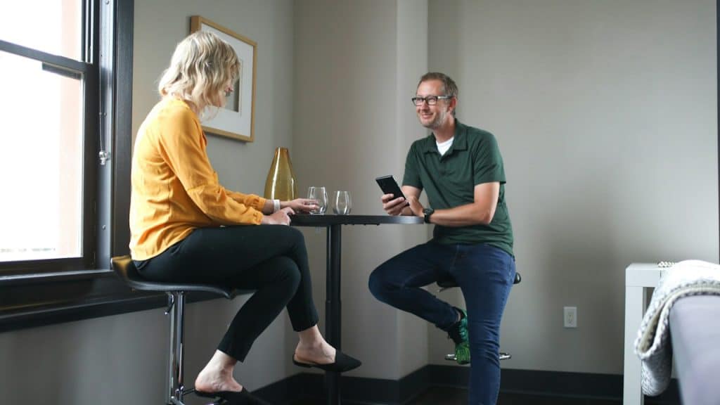 A man and woman conversing while sitting at a table.