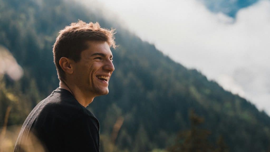 A man laughing and looking at the picturesque scenery around him.