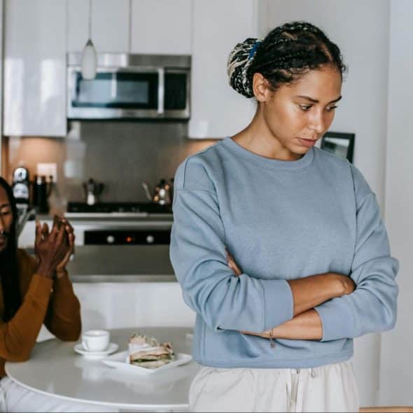 A woman looking sad and a man behind him