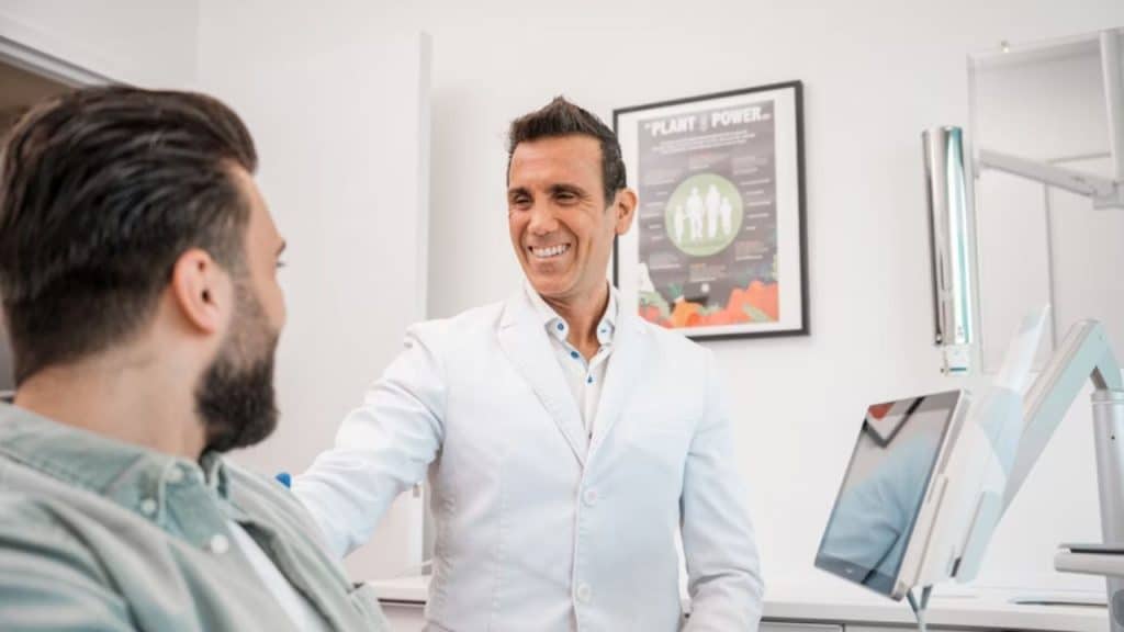 Man at a doctor’s office, smiling during a routine checkup