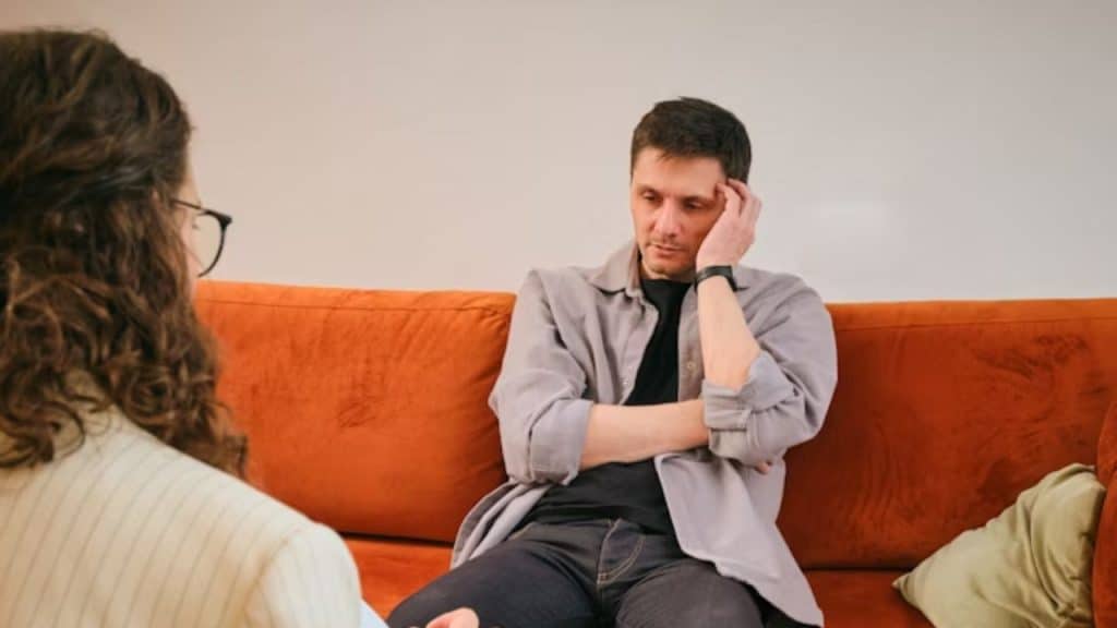 Man looking tired while listening to his partner speak critically