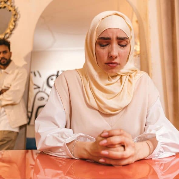 A woman crying and a husband watching her