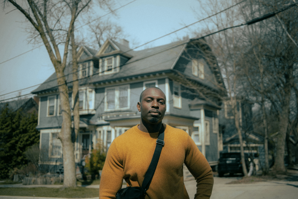 Confident man standing near a house.