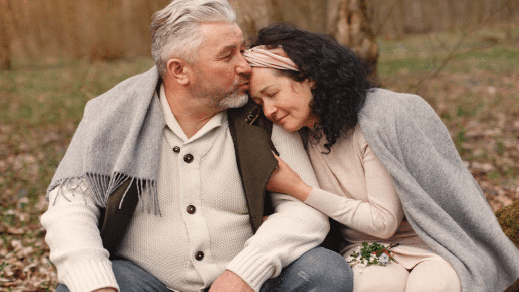A man kissing his wife on the forehead